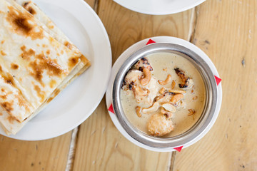 food, south asian cuisine, culinary and cooking concept - close up of chicken noorani in bowl on table of indian restaurant
