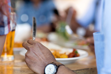 leisure, food and people concept - close up of african american man eating with friends at restaurant