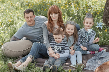 happy modern family with children sitting on the grass.