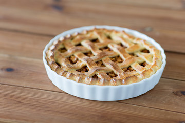 food, culinary and baking concept - apple pie on wooden table