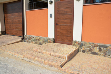 House entrance door with pavement, door bell, security camera, garage door