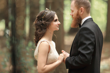 beautiful in love couple on the background of trees in the forest