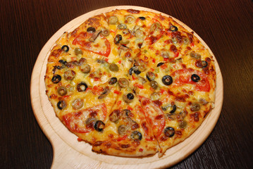 Pizza on the thin dough with cheese and olives