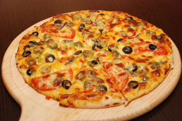 Pizza on the thin dough with cheese and olives