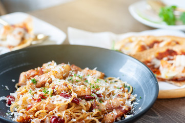 Italian food set, spicy spaghetti bacon with  roasted chilli and crispy shrimp on woodent table in restaurant.