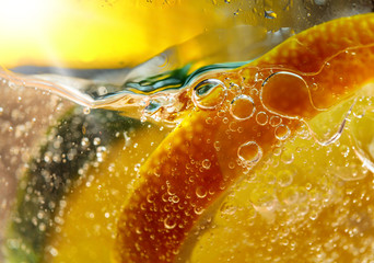 Carbonated drink or cocktail with lemon, abstract splashing.