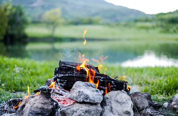 Camping with a fire in the mountains near the lake
