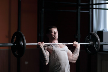 Fototapeta na wymiar male bodybuilder doing exercises with a barbell