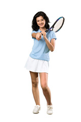 A full-length shot of a Young tennis player woman points finger at you with a confident expression over isolated white background