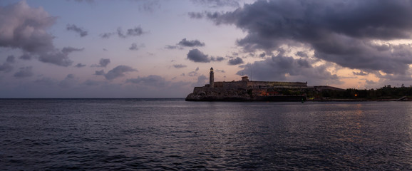 Naklejka premium Beautiful Panoramic view of the Lighthouse in the Old Havana City, Capital of Cuba, during a colorful cloudy sunrise.