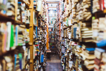 selective focus of vintage books on wooden shelves in library