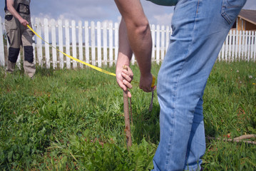 workers measuring land with a ruler