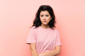 Obraz premium Young woman over isolated pink background having doubts and with confuse face expression