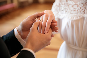 the bridegroom puts the ring on the bride and holds her hand