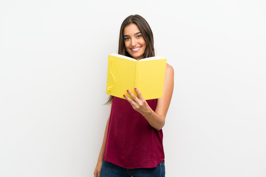 Young Woman Over Isolated White Background Holding And Reading A Book