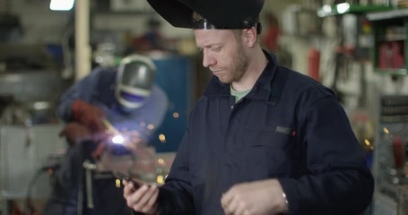 4K Mechanic business owner speaking angrily on phone in garage workshop