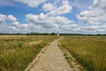 The road leading through the meadow to the Church of the Intercession on the Nerl summer day