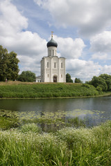 Fototapeta premium White stone Church of the Intercession on the Nerl with reflection in the water summer day Russia