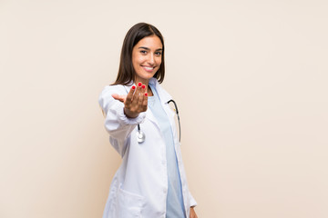 Young doctor woman over isolated background inviting to come - obrazy, fototapety, plakaty