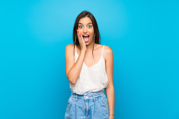 Young woman over isolated blue background with surprise and shocked facial expression - obrazy, fototapety, plakaty