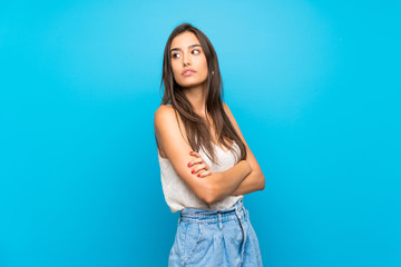 Fototapeta na wymiar Young woman over isolated blue background portrait