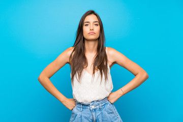 Young woman over isolated blue background angry