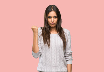Young hispanic brunette woman with angry gesture over isolated background