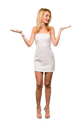 A full-length shot of a Young blonde woman holding copyspace with two hands over isolated white background