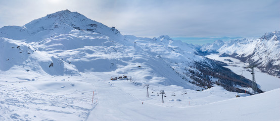 Panorama of the winter snowy mountains with frozen lakes in the valley. View to Corvatsch near St. Moritz in Switzerland.