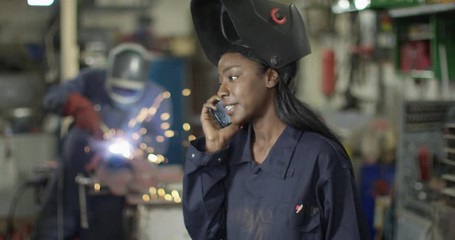 4K Female mechanic business owner dealing with a problem on phone in workshop