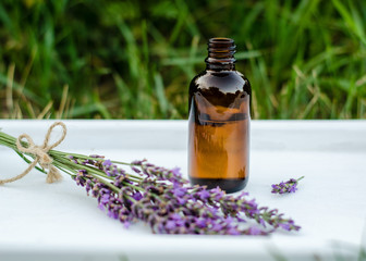 Lavender essential oil. Dark bottle of essential oil with fresh lavender twigs.  natural face and body beauty care concept.