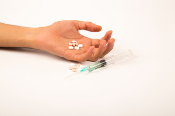 .Drug addiction concept - passive hand with coat, pills and injection, on white and isolated background
