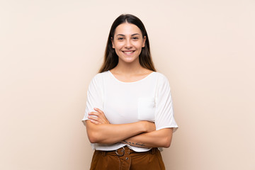 Young brunette woman over isolated background keeping the arms crossed in frontal position