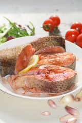 raw salmon steak with salad and vegetables