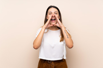 Young brunette woman over isolated background shouting and announcing something