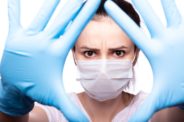 Fototapeta na wymiar young woman in medical mask on her face, gloves on hands