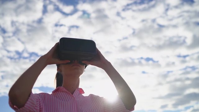 Young woman uses Virtual Reality Headset for traveling around the world