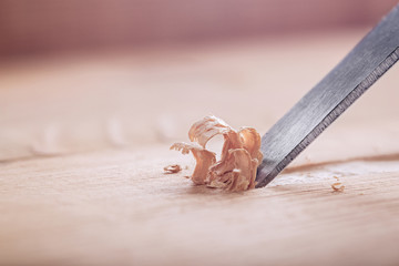wood chisel cutting out groove in old pine plank for the door lock