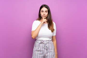 Young woman over isolated purple background showing a sign of silence gesture putting finger in mouth