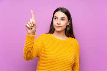 Young woman over isolated purple background touching on transparent screen