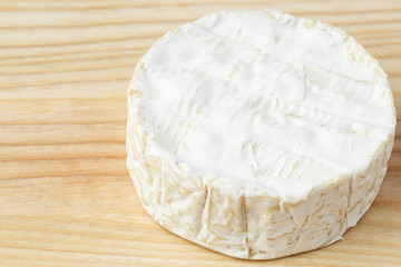 camembert soft cheese on wood background 