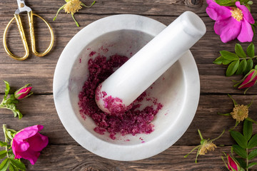 Rosa rugosa petals crushed with sugar in a mortar