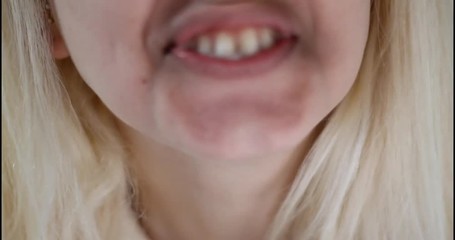 In and out of focus of woman spitting. Close up.