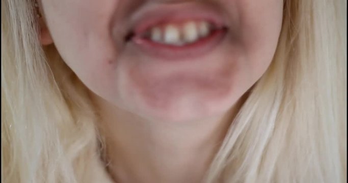 In and out of focus of woman spitting. Close up.