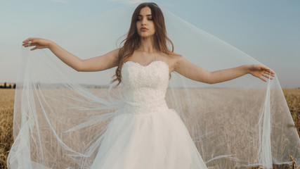 Beautiful bride in wheat field on sunset