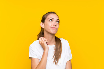 Young woman over isolated yellow background thinking an idea