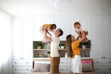 Caucasian family with two children hands in air