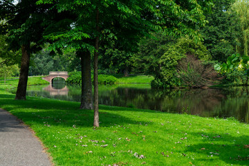 Ditch, canal, bridge and green trees in public park of Kampen, The Netherlands