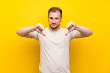 Handsome man over yellow background proud and self-satisfied