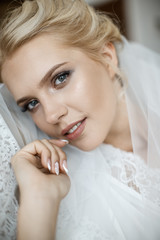 A young bride is laying on the couch closeup. She is looking at the camera.